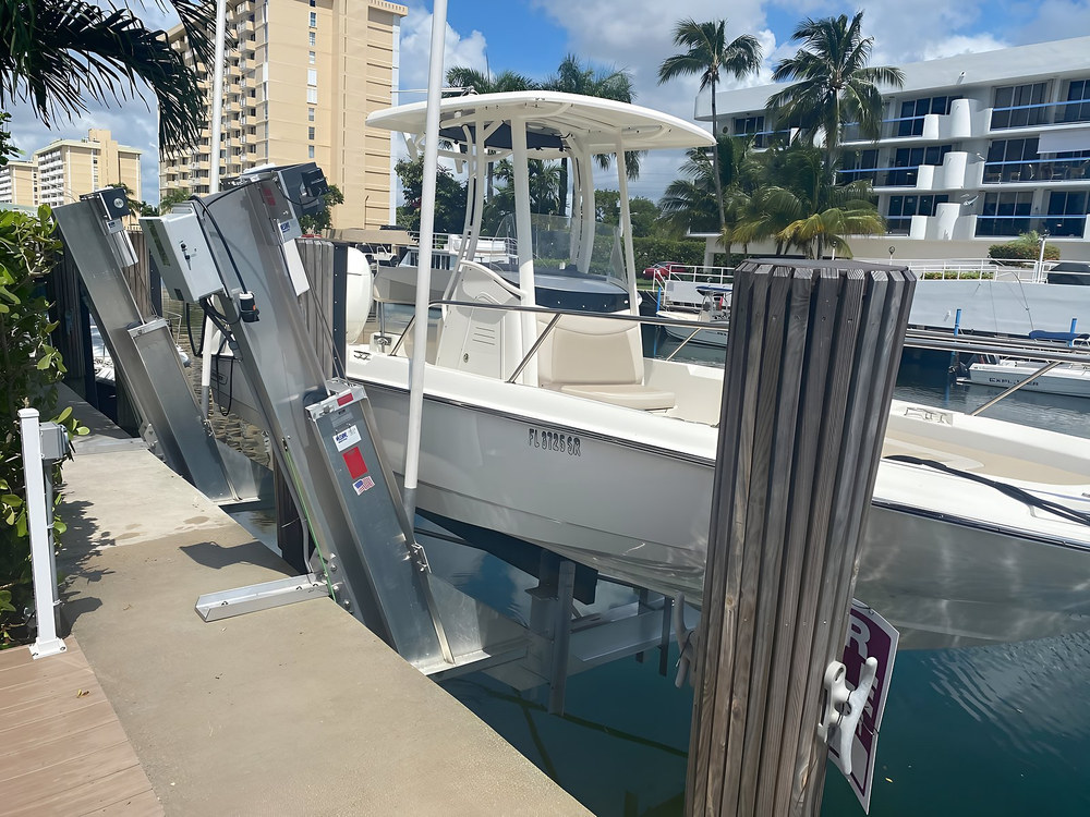 Vertical aluminum boat lift with center console and dual motor control box — South Florida waterfront by Contour Marine