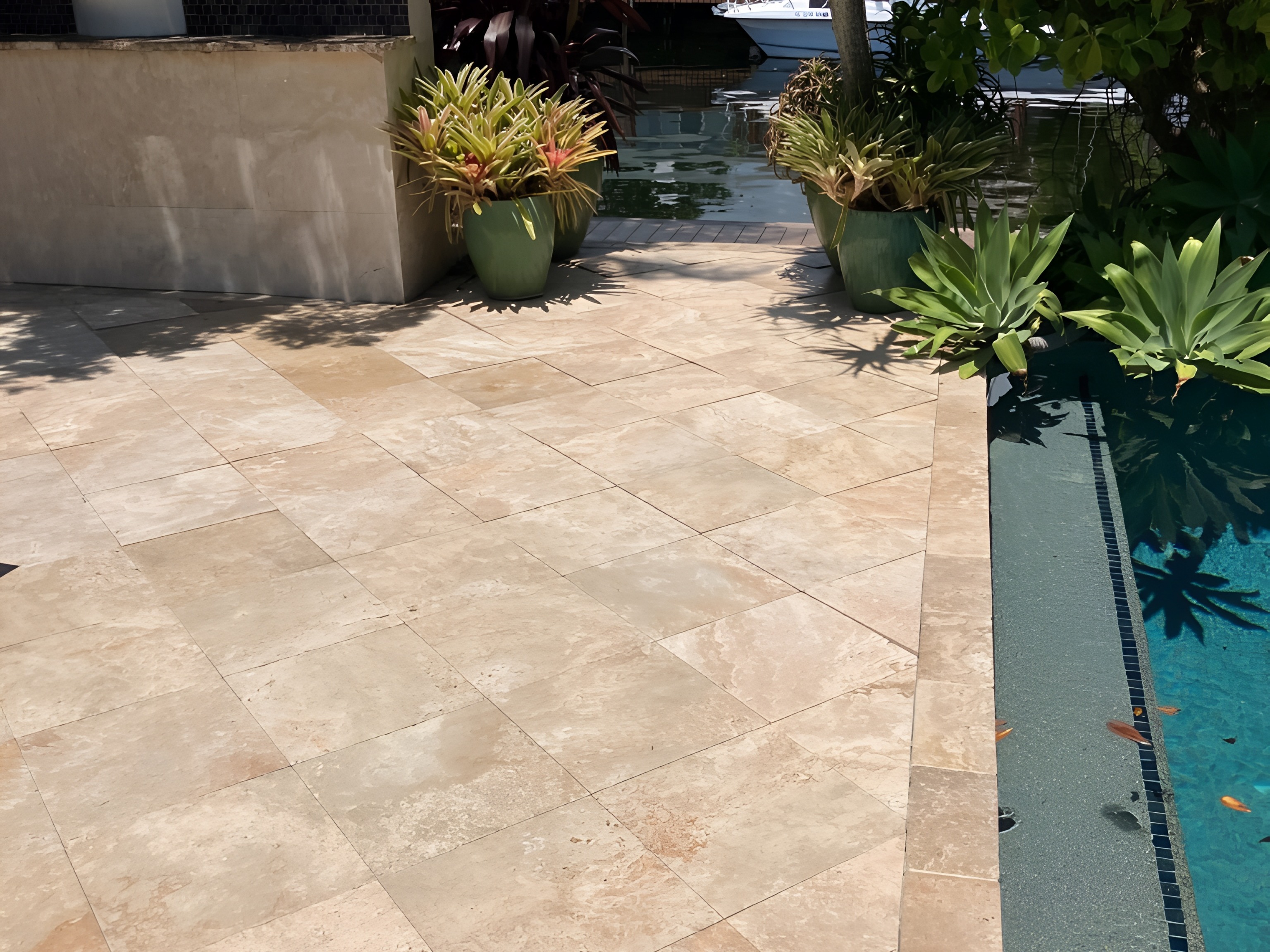Elegant travertine deck with outdoor kitchen beside South Florida canal — Contour Marine