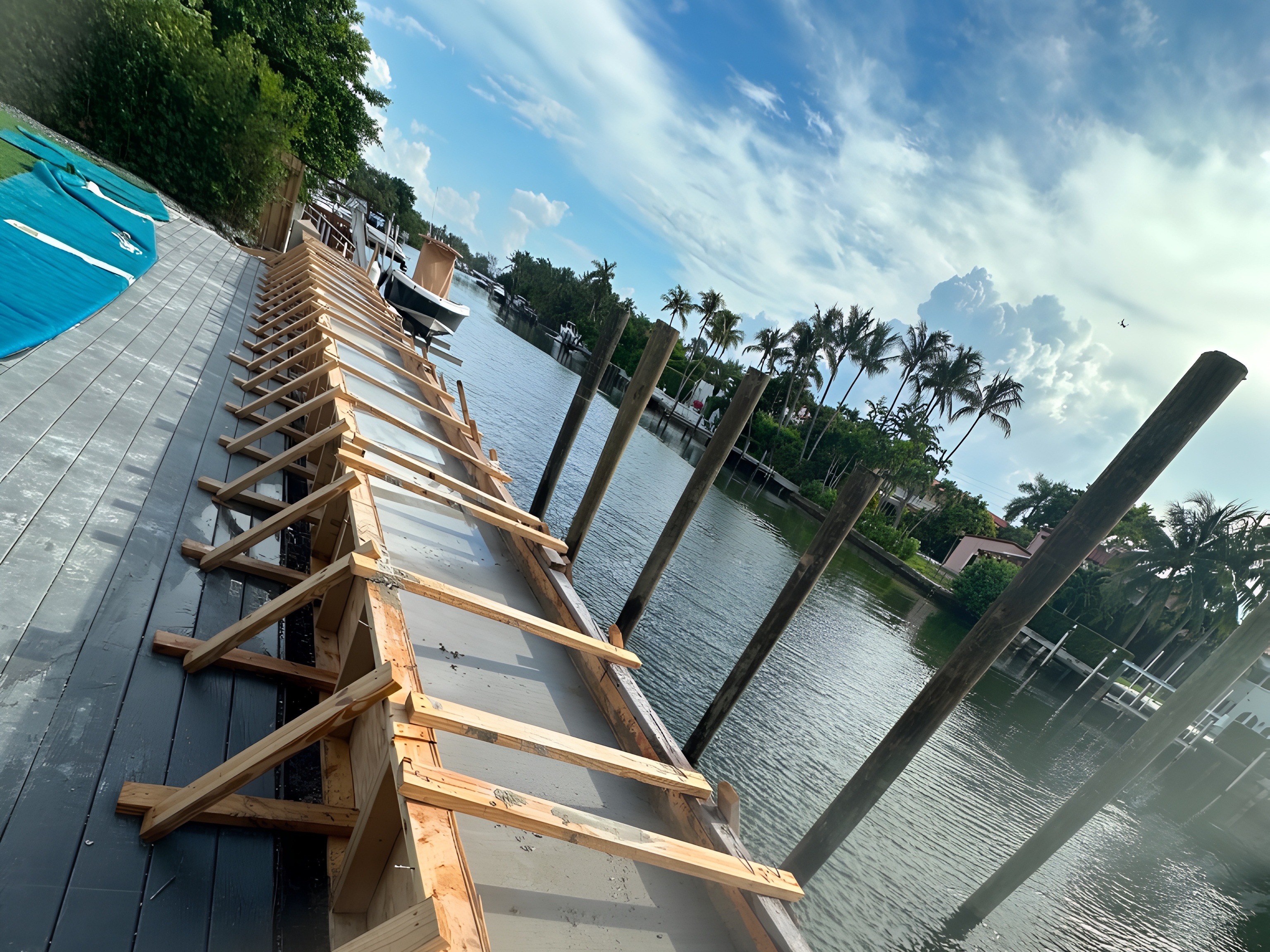 Completed seawall cap angle view with pilings and South Florida canal — Contour Marine